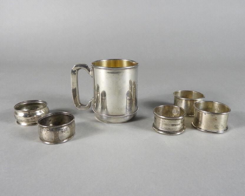 Sterling Silver Christening Mug & Rings: An early 20th century sterling silver christening mug with beaded decoration, monogrammed and dated 1903, the interior with a faint gilt wash and raised on a conforming foot (dented), the underside st