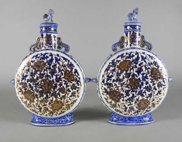 Pair of French Faience Moon Flasks, 19th Century: A pair 19th century French faience pottery moon flasks in the Chinese taste, decorated overall with flowering vines in a palette of cobalt blue, russet and gilt, rising up to cylindrical necks and sto