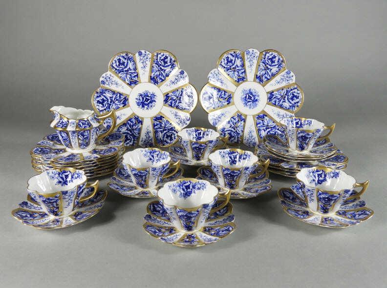 The Foley English Partial Tea Service: An early 20th century The Foley English porcelain part tea service in the Snowdrop Shape 'Rose Panels' pattern #6924, consisting of 7 tea cups, 9 saucers, 10 side dishes (7.25" d), 2 platters (9.5" d)