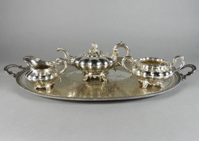 Hallmarked Silver Tea Set & Silver Plated Tray: An English sterling silver 3 piece tea set of melon form, consisting of a teapot hallmarked London 1856 and engraved with a heraldic crest, an associated cream jug hallmarked London 1849, and an assoc