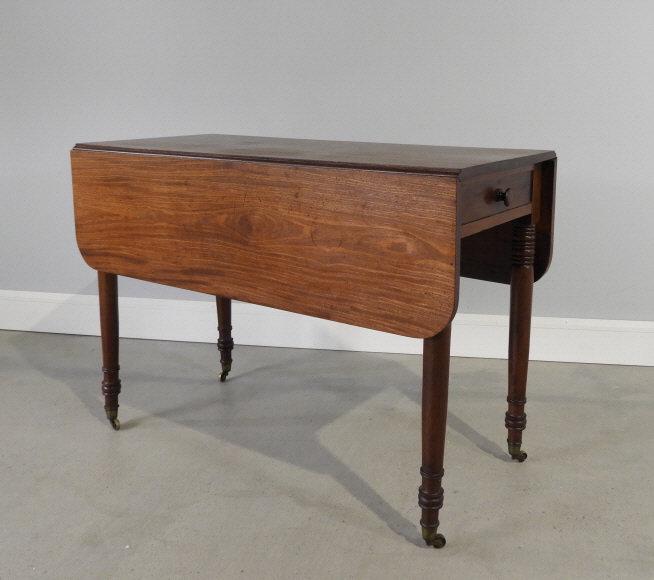 Mahogany Pembroke Table, Circa 1820: An early 19th century mahogany Pembroke table, the rectangular top having twin hinged leafs braced by 2 pairs of gate-leg supports, the frieze fitted with a small drawer at one end and a false drawer