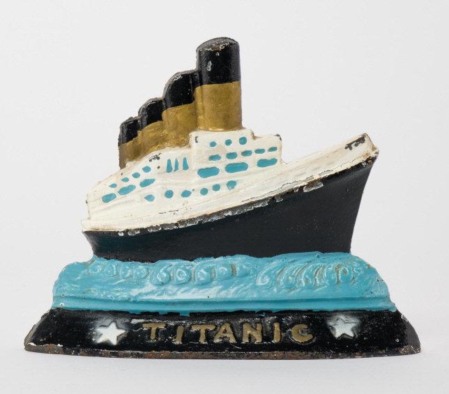 Antique Titanic Door Stop: An antique painted cast iron novelty door-stop titled 'TITANIC'. Measuring: 6.5" high x 8" wide.