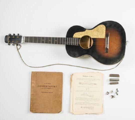 Hawaiian Guitar: A student quality Hawaiian guitar in burnt umber with gold sparkle pick guard & fret markers, in cardboard case with Hawaiian guitar music books, finish lifting, one string & peg missing, case in roug