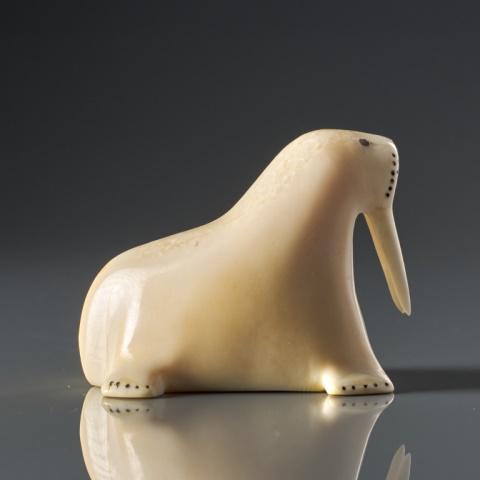 WALKER KOWANNA, WALRUS: Walter Kowanna, natural material, walrus carved from a single piece -- the eyes, whiskers, mouth & claws highlighted with engraved work, signed. Measuring, 2.5” x 1.5” x 2”. CITES ru