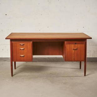 MCM TEAK KNEEHOLE DESK BY HVIDT & MOLGAARD: For Soborg, Denmark circa 1960, the rectangular top over a compliment of drawers with molded recessed pulls, raised on turned & tapering supports, measuring 29" high x 60" wide x 33" deep.