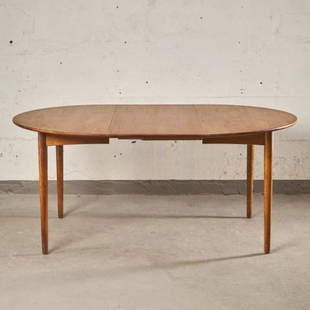 MCM DINING TABLE BY BORGE MOGENSON (1914-1972): For Soborg, Denmark circa 1960, the oval shaped teak top raised upon four turned & tapering supports in oak, measuring 28.5" high x 45" long (65" with leaf inserted) x 45" wide.