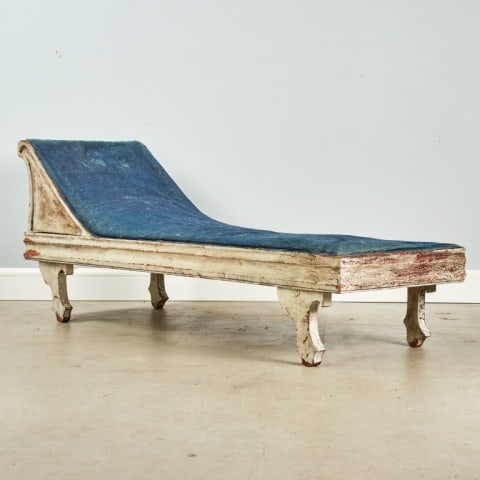 COUNTRY CHAISE LONGUE: In excellent white painted surface, showing considerable age, and upholstered in a navy blue jean-like cotton fabric. This form is more often country formal. Lunenburg County (Nova Scotia), circa 1870