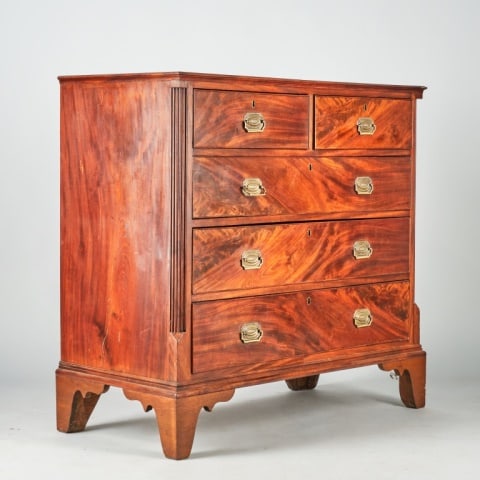 GEORGE III FLAT FRONTED CHEST OF DRAWERS: British, circa 1770, the figured mahogany case with reeded 1/2 columns, fitted with two short drawers over three tiers of graduated full width drawers, all with original lock mechanisms & replaced per