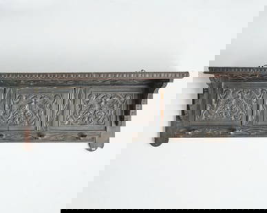 ARTS & CRAFTS CARVED COAT RACK: English circa 1900, the flattened hat shelf braced by shaped supports over a carved frieze of organic motifs, measuring 14" high x 39.5" wide x 9.5" deep.