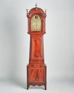 CANADIAN MAHOGANY LONGCASE CLOCK BY SAVAGE: Montreal Canada, circa 1835, the highly figured mahogany case showing a hood with a carved crestrail decorated with brass finials and barley twist columns, over a glazed arched door and glazed side pa