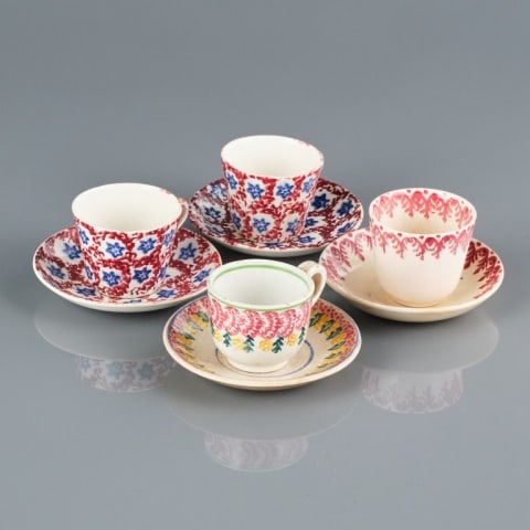 PORTNEUF SPONGEWARE DEMI-TASSES: Scotland, four Portneuf spongeware demi-tasse cups and saucers, two in an overall striking blue and red pattern (2.5/8" dia.), one in red only, and another with red, yellow and green. All in very good