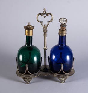 HAND-BLOWN CLARET JUGS WITH STAND: Circa 1850, one blue and one green jug, resting in the original silver plated stand, 12.25 inches high.