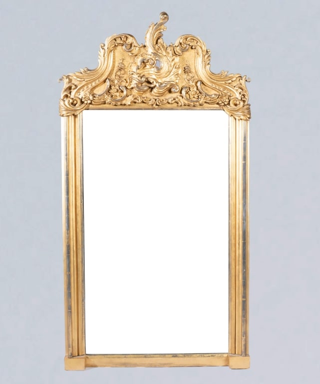 FINE BELLE ÉPOQUE GILTWOOD PIER MIRROR: French, circa 1870, the finely gilded frame showing a pediment with a rocaille cartouche of leafy scrolls, over an old mirrored plate, minor losses and rubbing to gilding, measuring 56" high x 30 1/2"