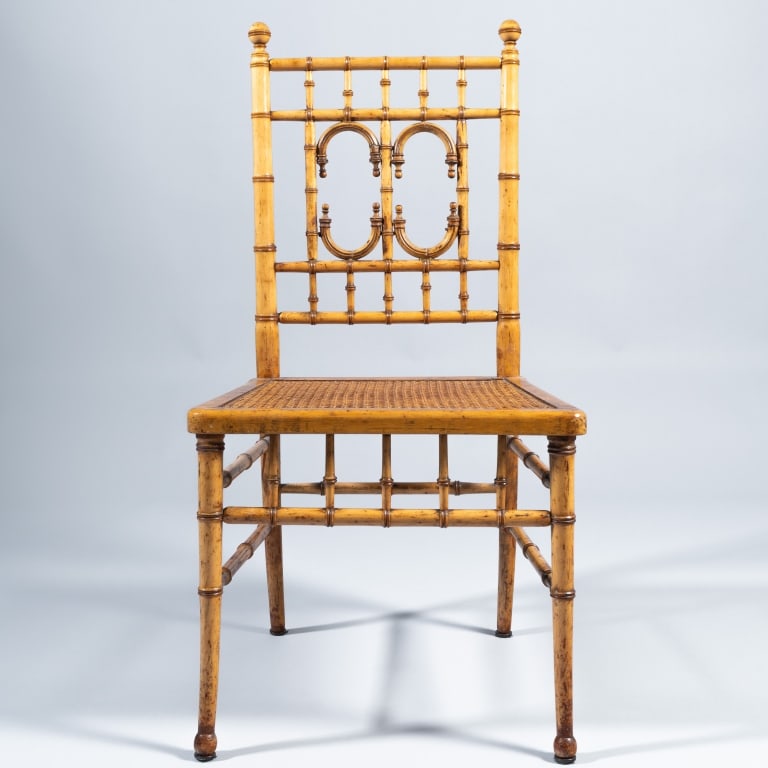 FAUX BAMBOO CHAIR: The turned maple frame with aesthetic backrest, ball finials and hand-caned seat, measuring 36 1/2" h x 18 1/4" w x 17" d. Condition noted, frame reinforced with screws.