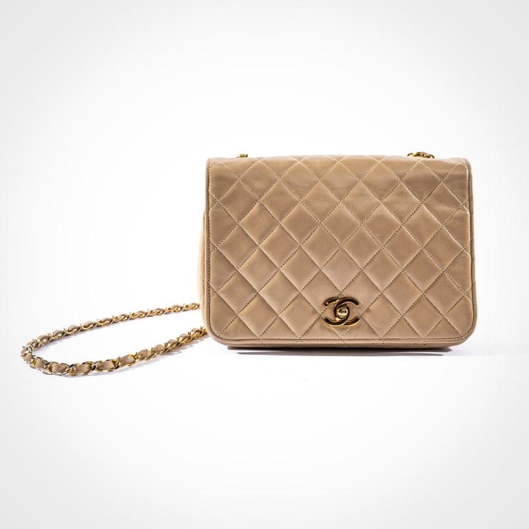 VINTAGE CHANEL PARIS SHOULDER BAG: The full-flap matelasse pattern shoulder bag crafted from beige quilted lambskin with 24K yellow gold plated hardware, including the woven leather and chain shoulder strap, comes with original felt Ch