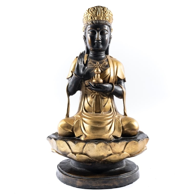CHINESE PARCEL GILT BRONZE GUANYIN STATUE: An antique parcel-gilt and patinated bronze figure depicting a seated Guanyin resting upon a double-lotus pedestal base, holding a double-gourd vase, 18 x 11 x 8 inches.