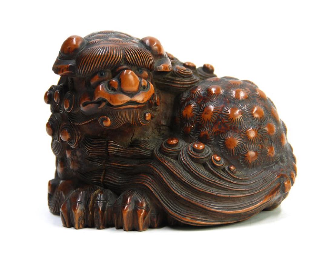A CARVED WOOD FIGURE OF FOO DOG, EDO PERIOD(1603-1867): A carved piece of wood in foo dog form. H:3 1/4in (8.2 cm) W:4 1/2in (11.4 cm)