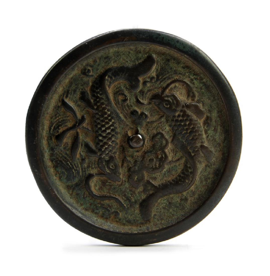 BRONZE MIRROR; JIN DYNASTY (1115-1234): A bronze mirror with two fish around its center. D:3 3/4in (9.5 cm)