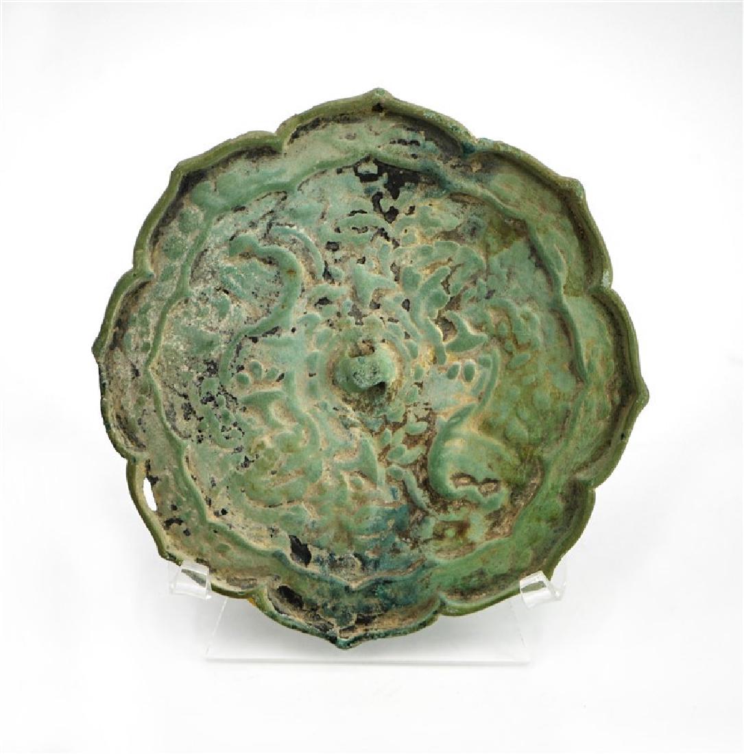 LOTUS SHAPE BRONZE MIRROR: This bronze mirror has petaled edges and a faint design on the back D:5in (12.7 cm)