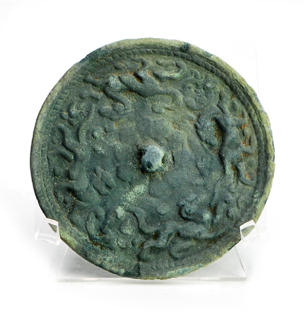 LEOPARD BRONZE MIRROR: Covered in a green patina, this bronze circular mirror has a design with leopards. D:3 3/4in (9.5 cm)