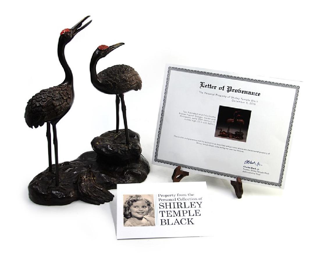 SHIRLEY TEMPLE BLACK POLYCHROME BRONZE FIGURAL STORKS: A pair of bronze cranes joined by a minogame, which is so old it has a train of seaweed growing on its back, is a symbol of longevity and felicity. FROM THE COLLECTION OF SHIRLEY TEMPLE BLACK H:13 3/4