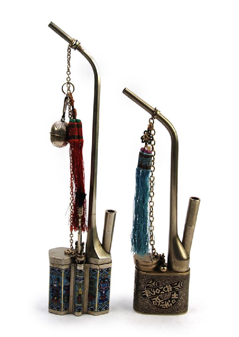 PAIR OF CLOISONNE OPIUM PIPES: Both silver toned, one is enameled with goodluck symboles, the other is cloisonned with images of vases, flowers, and ling zhi patterns. Decorative tassles, chains, and cleaning tool included. H:13in 