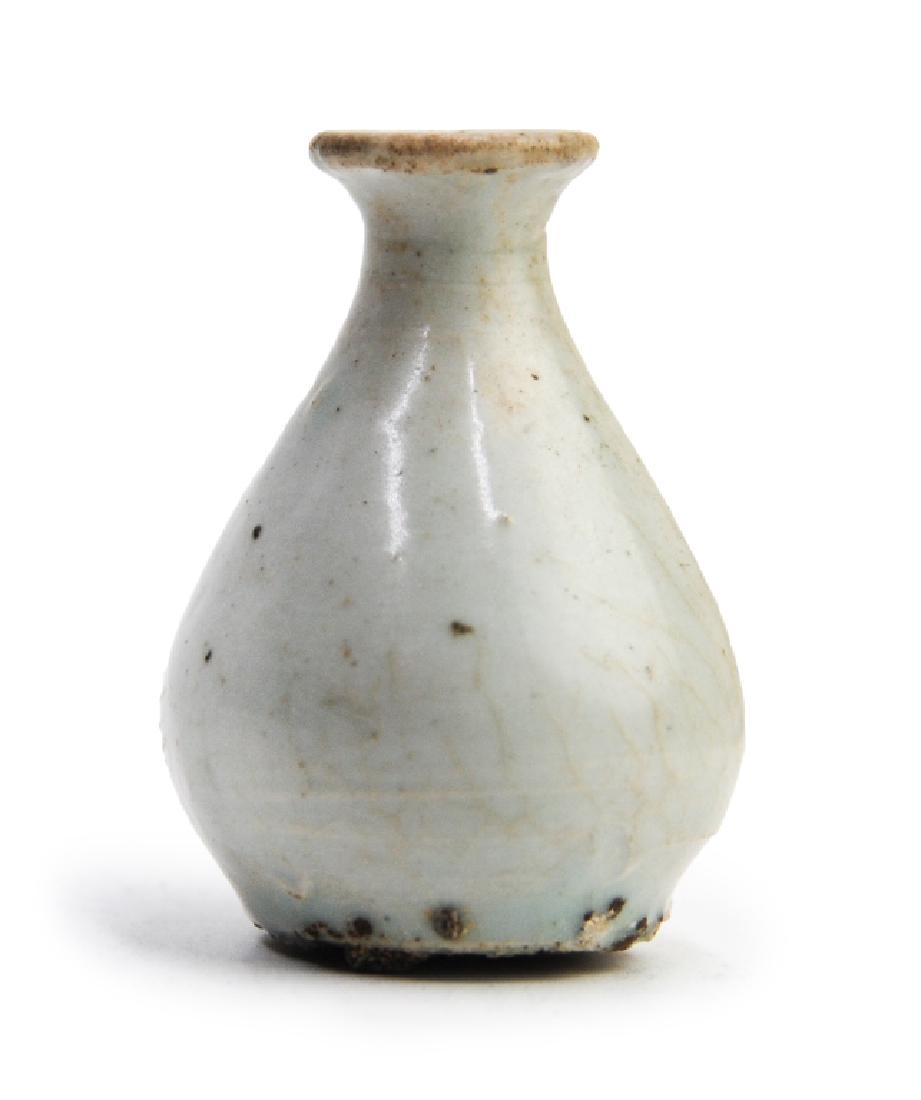 KOREAN WHITE GLAZED WINE BOTTLE: This small white glazed wine bottle is in a pear shape, with a thin neck and a flaring mouth. H:2 1/4in(5.7cm) W:1 3/4in(4.4cm)