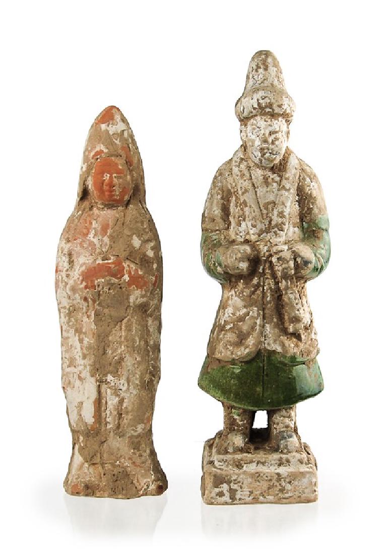 PAIR OF EARTHWARE FUNERARY ATTENDANTS: A pair of earthenware tomb attendants, one the left similar to Tang Dynasty styles and the right more to Ming Dynasty - both dress in long robes, head coverings and with hands held up near the chest.H