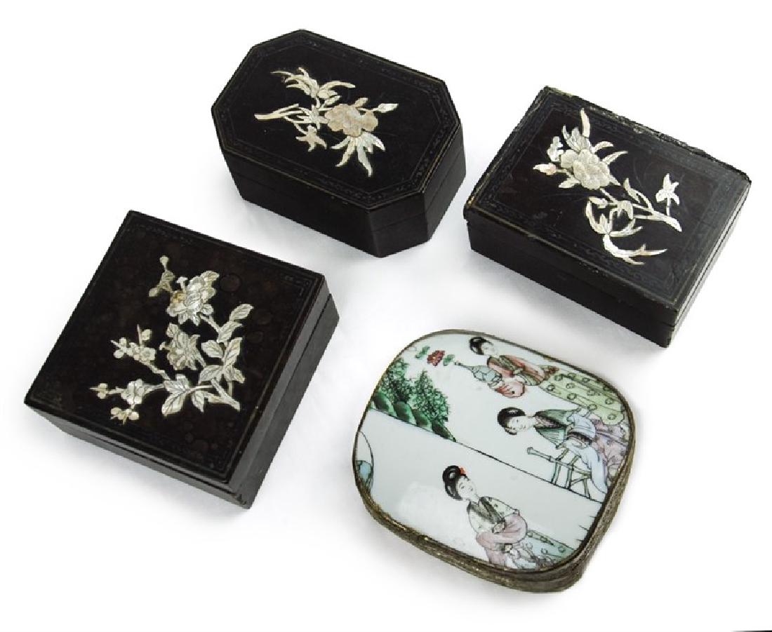 GROUP OF FOUR BOXES: Similar in size, this group of four boxes is comprised of three lacquer boxes and one porcelain. The black lacquered boxes are inlaid with carved mother-of-pearl flowers on the lids. The porcelain box
