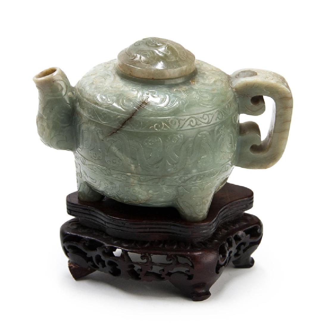 MING DYN HETIAN JADE CHI DRAGON VESSEL: A 17th century late Ming Dynasty carved hetian jade vessel covered with sinuous chi dragons around the body, spout, lid and bottom, along with a taotie beast mask handle sitting on three legs._x000D_ 