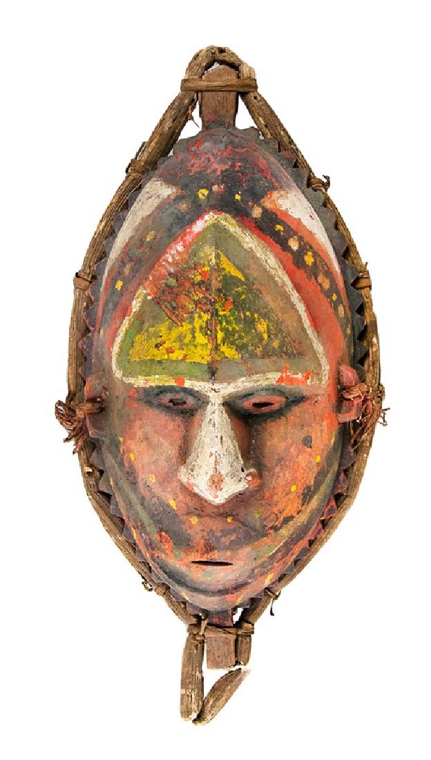 PAPUA NEW GUINEA RITUAL MASK: This Papua New Guinea mask from the Maurik Village is featured with an oval shape, a long forehead, a slender mouth, and a wide nose. The mask is in reddish-orange with a nose painted in white and a f