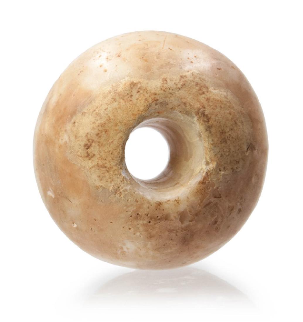 AN ALABASTER CARVED MACE HEAD: An Alabaster round carved mace head. _x000D_ H:1 1/2in(3.8cm) W:2 3/8in(6cm)