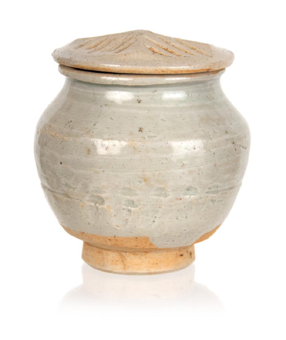 CHINESE SONG DYNASTY LIDDED JAR: A Qingbai Song Dynasty style tea caddy, covered in a pale blue glaze stopped at the foot revealing a biscuit body. H:3 1/8in(8cm) W:3in(7.6cm)