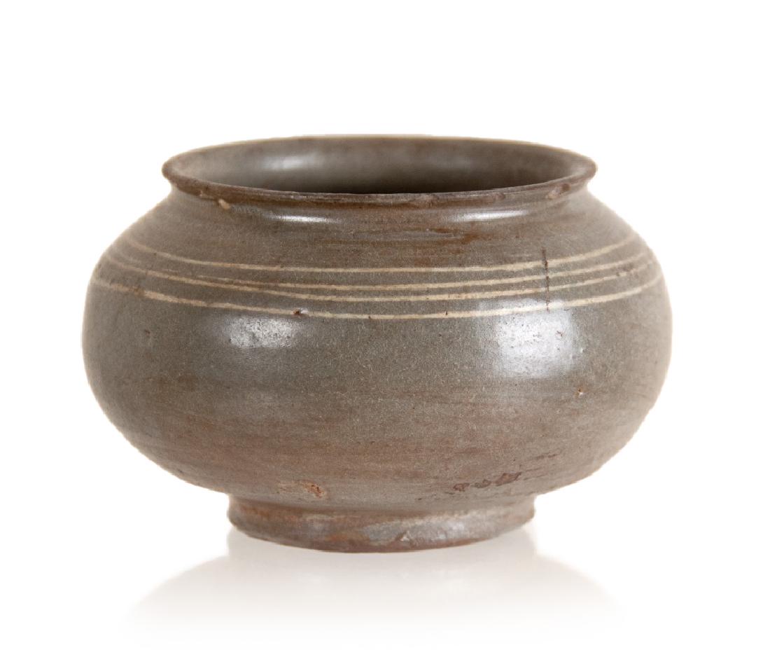 SMALL KOREAN JAR: A small squat Korean jar covered in a gray brown glaze and four slip inlaid rings. H:2 1/2in(6.4cm) D:4in(10.2cm)