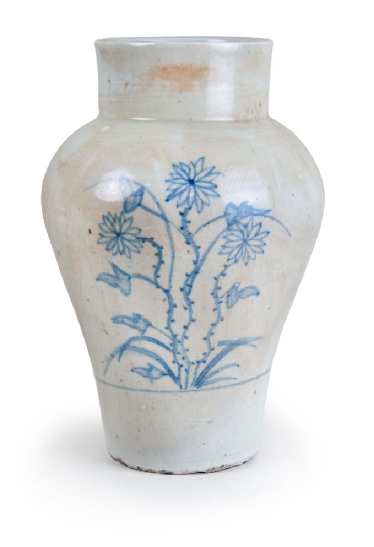 KOREAN BLUE AND WHITE VASE: A blue and white vase decorated with flowers on the body, featured with a wide shoulder and a thick straight neck. H:10 3/4in(27.3cm) W:7in(17.8cm) M:3 3/4in(9.5cm)