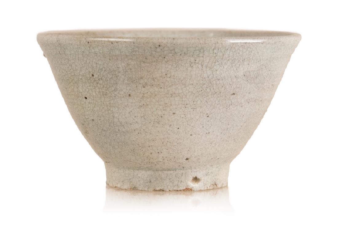 KOREAN EARTHENWARE BOWL: A conical cream colored Korean bowl covered in a crackled glaze. H:3 1/4in(8.3cm) D:5 3/4in(14.6cm)