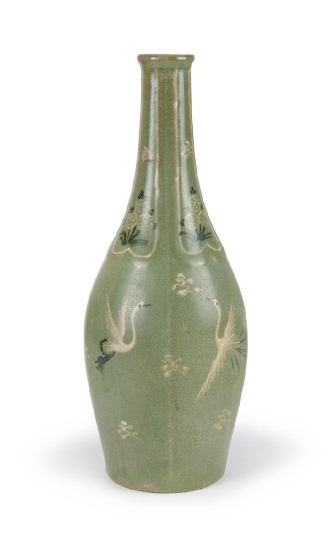 A KOREAN CELADON VASE WITH CRANES DECORATION: A tall and thin celadon bottle vase, with a faint lobed form, the neck bearing slip inlaid flowers and the body with cranes. H:10in(50.3cm) W:4in(10cm)