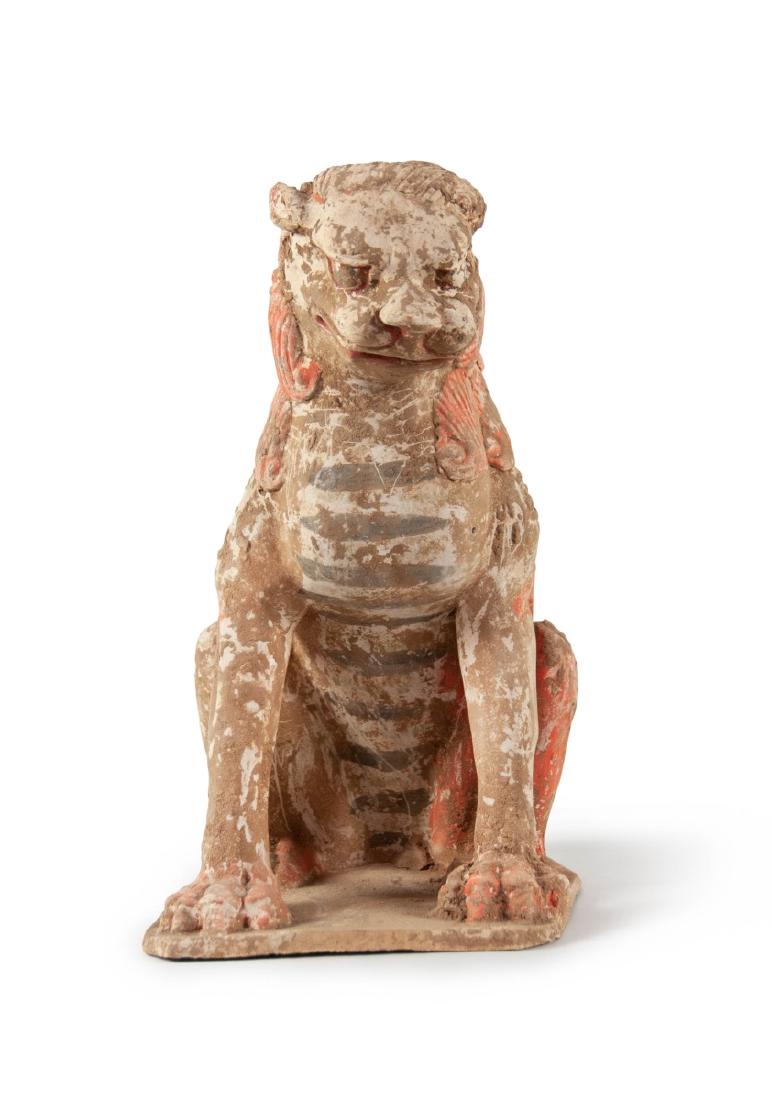 POTTERY FIGURE OF LION: Chinese Tang Dynasty pottery model; of a stylized lion seated on its haunches; with well detailed facial features; upon a shaped base. H:12 1/2in(32.1cm) W:7in(17.7cm)