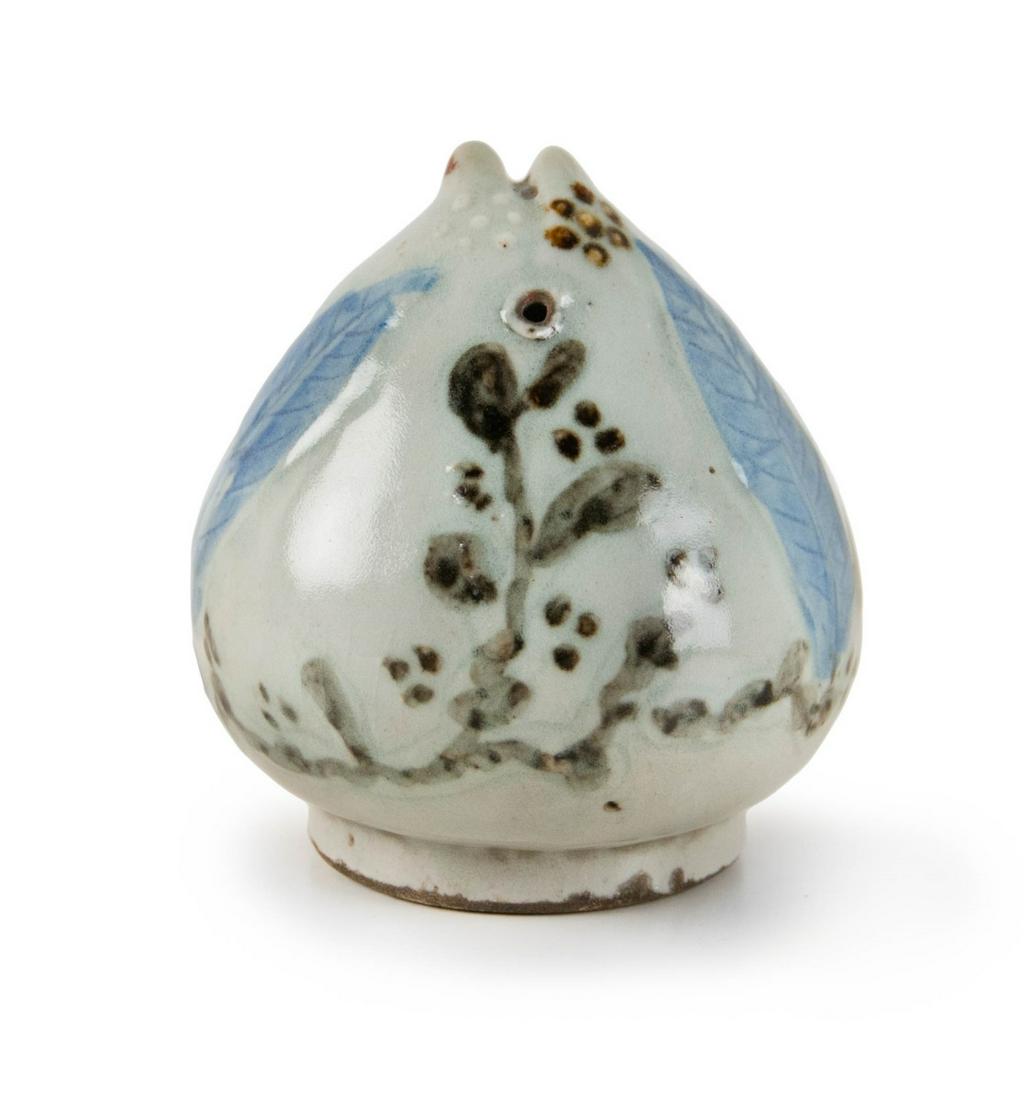 A KOREAN PEACH SHAPES WATER DROPPER: Joseon dynasty (19th century) Modeled in the form of a large Peach of Immortality, two side leaves applied with underglaze-blue, applied with a glossy clear glaze H:4 1/4in(10.7cm) W:4in(10.1cm)