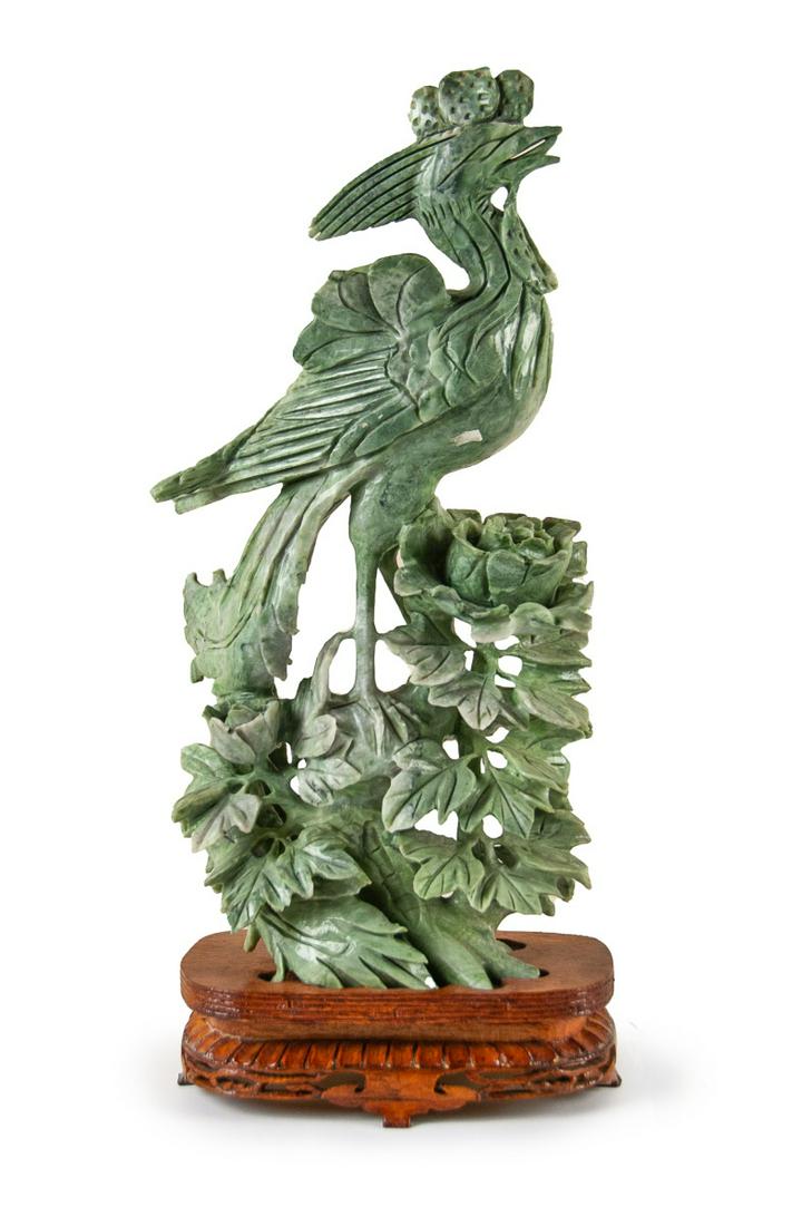 CARVED JADE FIGURE PHOENIX AND PEONY: Green carved jade bird on wood stand, China, late nineteenth to early twentieth century; unmarked. H:14 1/2in(36.8cm) W:6in(15.2cm) Weight:4.5 Lbs