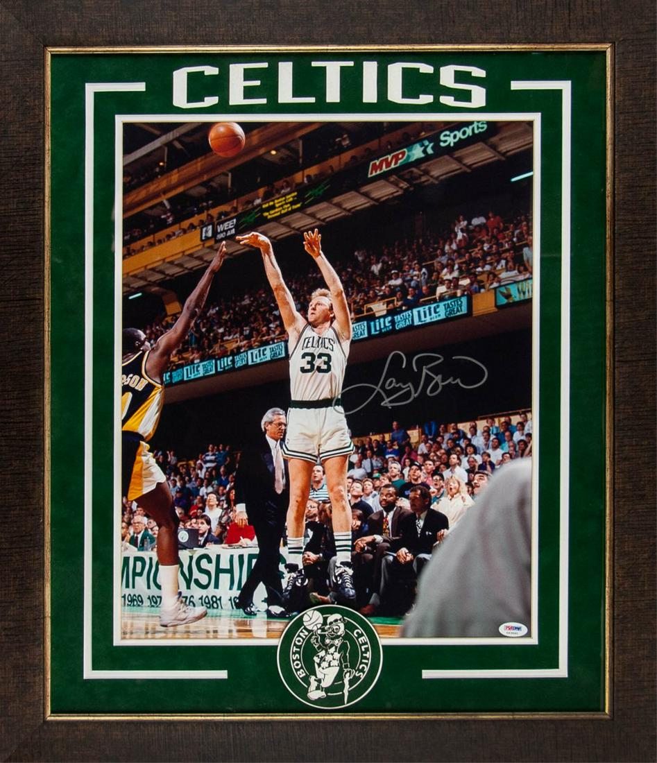 LARRY BIRD SIGNED BOSTON CELTICS JUMP SHOT PHOTO: Framed color print depicting Larry Bird of Boston Celtics shooting a half court corner shot. Signed by Larry Bird in silver toned mark. H:27 1/2in(69.8cm) W:23 1/2in(59.6cm)