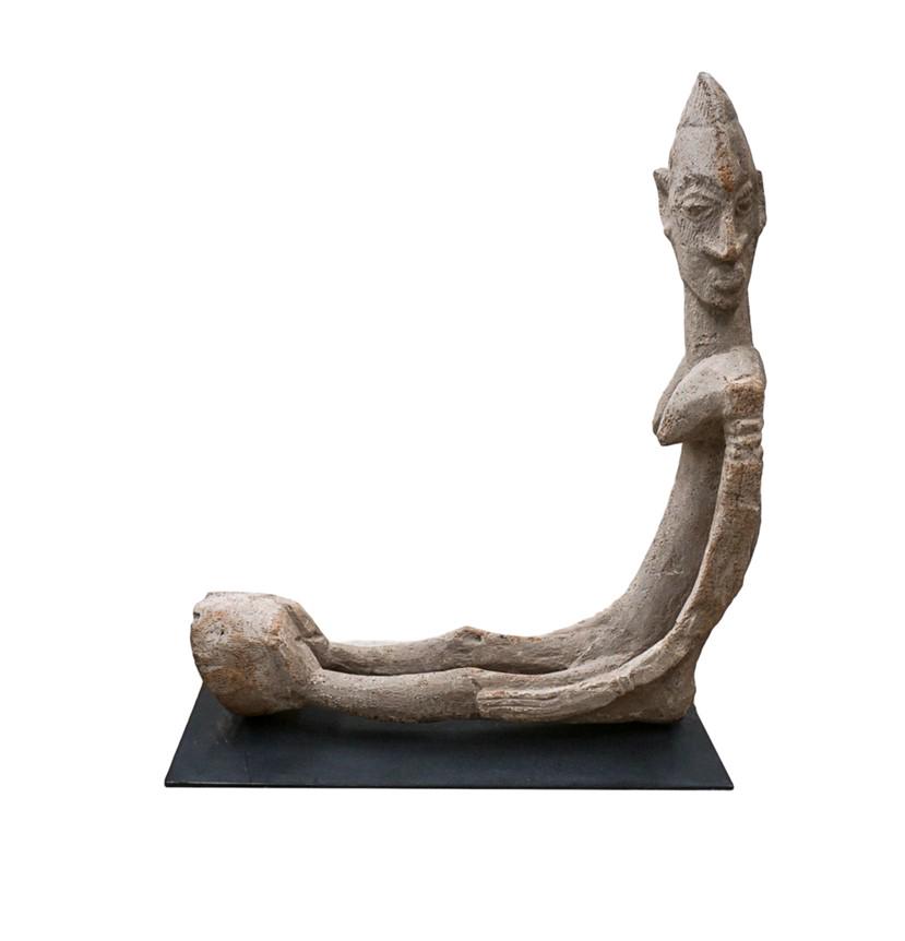SCULPTURE WOOD FIGURE,FEMALE , PAPUA NEW GUINEA: Sculpture in carved hardwood fabrication. Country of origin: Papua New Guinea. Depicts a figure with a hoof attached to its feet. Female, and mounted to an ebony tone metal base H:23.5in(59.6cm) W:21i
