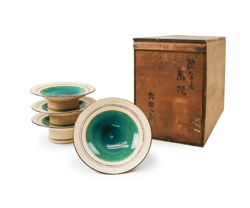SET OF FOUR JAPANESE TURQUOISE ALTER DISHES: A set of four Japanese high foot dishes glazed in green around the center and surrounded by a brown and a blue ring, with original box. H:2in(5cm) D:6in(15.2cm)