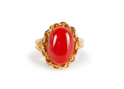 GOLD AND CORAL RING: The ring features a oval-shaped AKA coral cabochon, set in 18k gold. 6g 1.4cm X 1cm