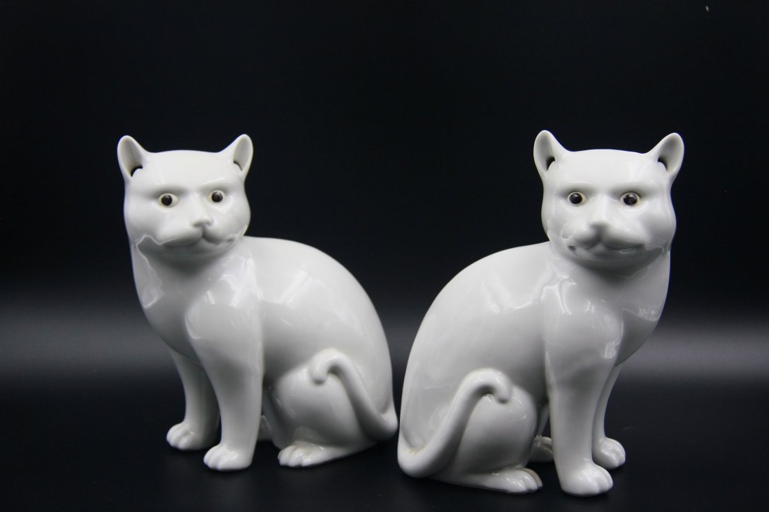 PAIR OF WHITE GLAZE CATS: Made in the early 20th century; finely glazed; a pair of white cats with vivid facial expressions; H: 8’’