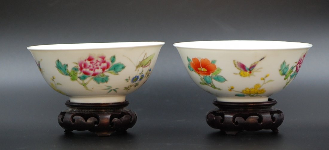PAIR OF BUTTERFLIES AND FLOWERS BOWLS: One is painted with peonies and grasshoppers, the other is painted with common garden peonies and butterflies, both in vivid colors and bearing hollowed wood stands. H:2” M: 5”