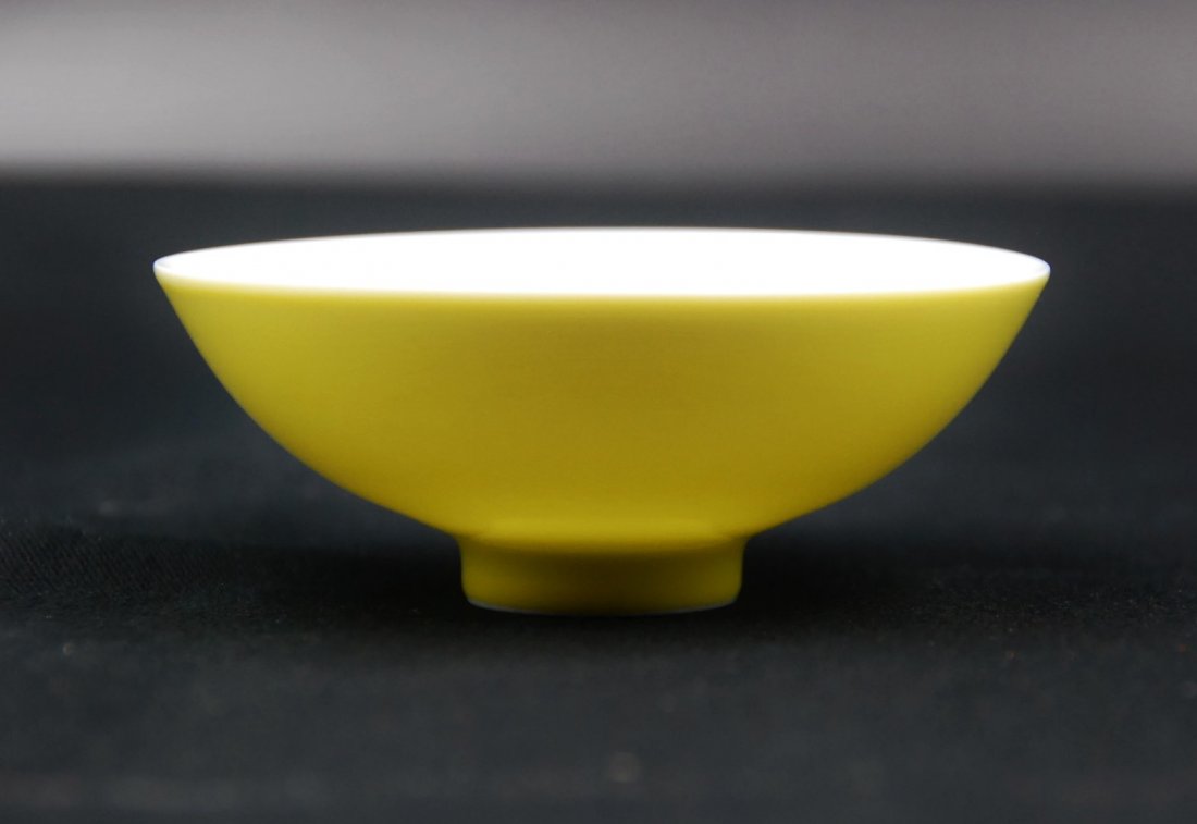 GUANGXU IMPERIAL YELLOW BOWL: This bowl is evenly glazed in lemon yellow on the exterior, and milky white on the interior, bearing a Guangxu mark at the bottom.H:1 ½” W:3 ½”