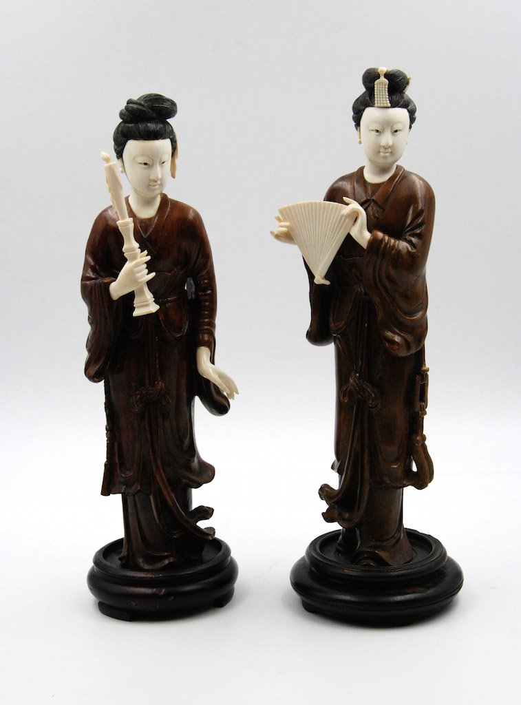 A PAIR OF QING DYNASTY HUANGYANGMU JAPANESE COURTESANS: Left: The hand and head are carved from bone, the body from wood, and rests upon a dark wood stand. Shown standing dressed in billowing robes, face with serene expression and hair arranged in a tall c