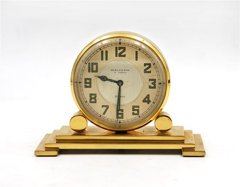 WALTHAM JEWELRY GOLD TONED DESK CLOCK: Geometric in design, this Waltham desk clock has two faces and a wind-up knob on the bottom. L:6 H:4