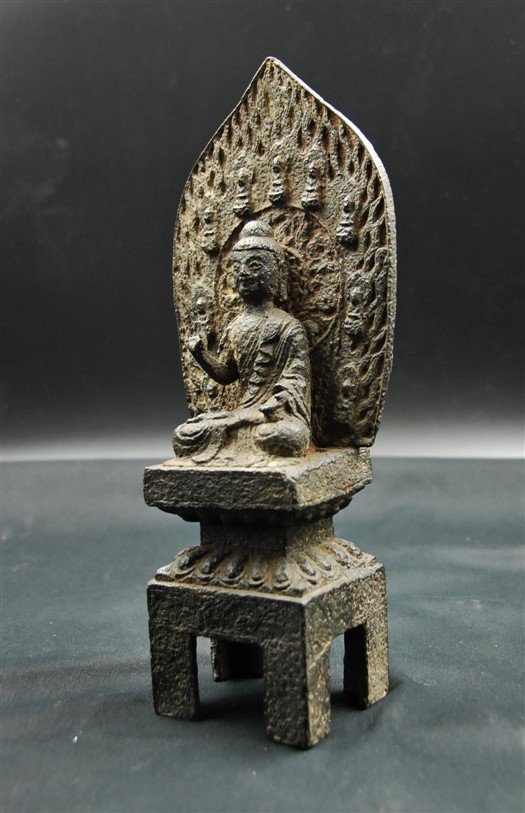 MING DYNASTY IRON BUDDHA: A vintage piece with unique design, this Buddha is sitting against the background of fire flame with tiny Buddha figurines along the edge. H:12 W:4 1/2